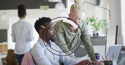 Collaborating coworkers reviewing interactive dashboard with HUD overlay in modern office