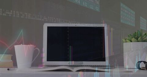 Laptop with stock charts on modern workspace desk with accessories