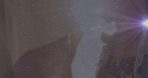 Cinematic reunion under starlit sky with mysterious lens flare