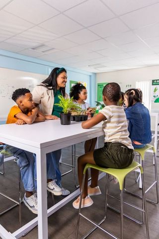 Teacher guiding diverse elementary students in hands-on plant science classroom activity