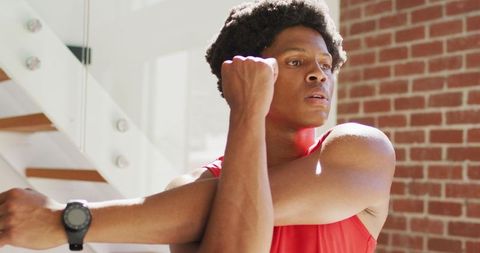 Fit Man Engaging in Home Stretch Routine in Sunlit Room
