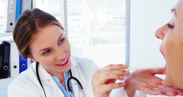 Smiling Female Doctor Examining Patient's Throat in Clinic - Download Free Stock Images Pikwizard.com