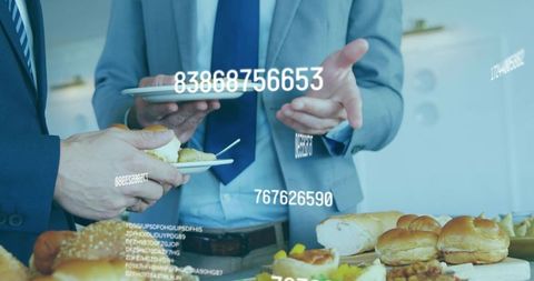 Businessmen networking over office buffet while reviewing tablet data analytics