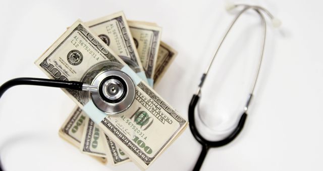 A stethoscope lies on top of a pile of US dollar bills, symbolizing the intersection of healthcare and finance, with copy space. It suggests the high costs of medical care or the economic aspects of the healthcare industry.
