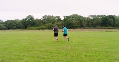 Two men jogging together in scenic park