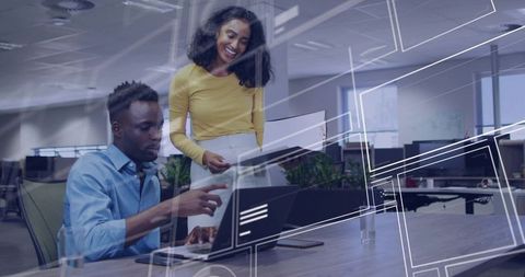 Two professionals collaborating over laptop with digital interface overlays in open office