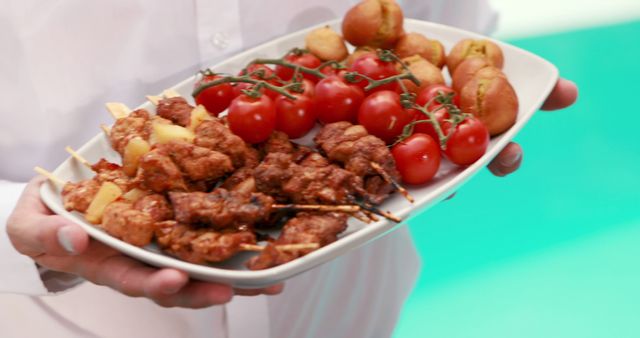 A chef presents a plate of delicious grilled skewers with meat, cherry tomatoes, and potatoes, with copy space. Such a display showcases culinary skills and the appeal of barbecued dishes.
