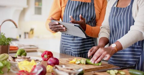 Senior Couple Cooking Together While Using Tablet for Recipes