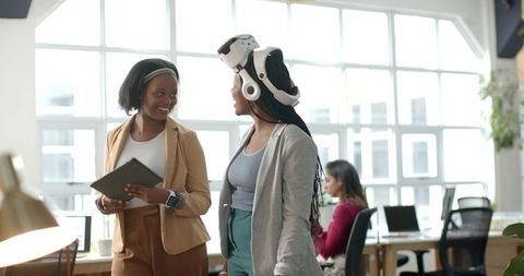 African American Colleagues Collaborating in Modern Open-Plan Office Wearing VR Headset
