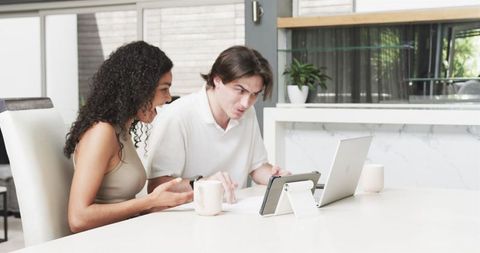 Happy Multiracial Couple Working Together at Home with Laptop