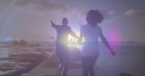 Couple Running Joyfully by the Sea at Sunset