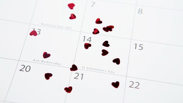 Red heart confetti placed on a calendar, highlighting February 14th, Valentine's Day. Suitable for use in articles, promotions, or designs related to Valentine's Day celebrations, romance, special dates, or marketing romantic events and gifts.