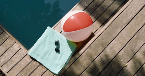 Sunny poolside retreat with beach ball and towel