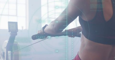 Digital fitness technology on woman rowing in gym