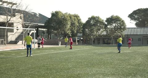 Youth Soccer Players Practicing Penalty Kicks on Sunny School Field