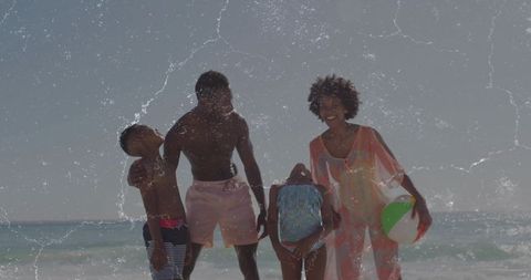 Joyful family enjoying beach day with inflatable beach ball