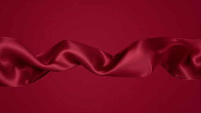 Elegant fluid red satin ribbon creating dynamic s-shaped wave