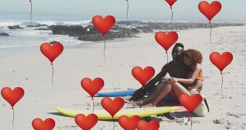 Romantic beach date with surfboards surrounded by digital hearts