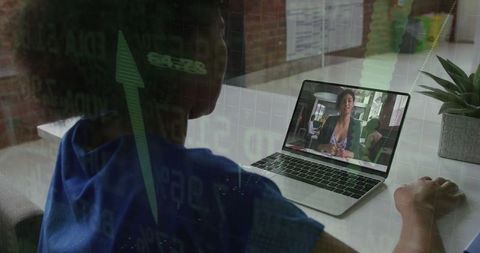 Woman Monitoring Financial Data on Laptop in Loft-Style Office