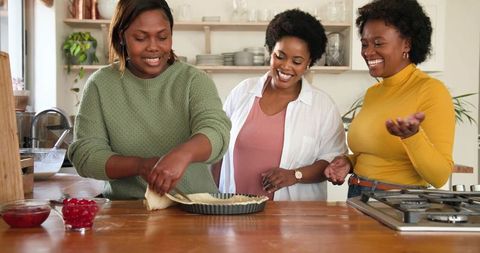 Group of friends baking together in modern kitchen