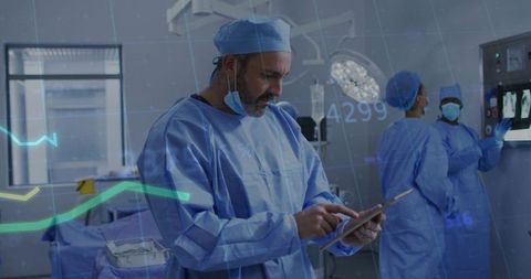 Surgeon Reviewing Digital Patient Data on Tablet During Team Surgery in High-Tech OR