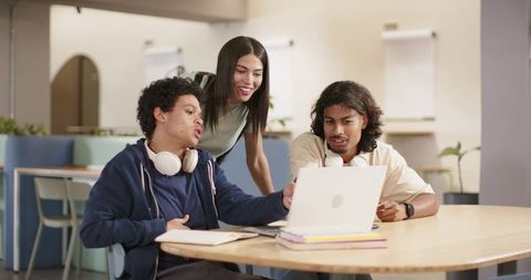 African American students collaborating on laptop in modern study lounge for group learning