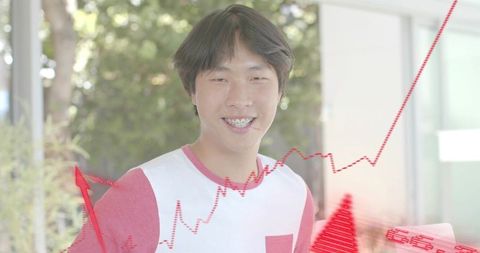 Smiling Asian man with braces wearing white tee posing with red analytics overlays rising chart