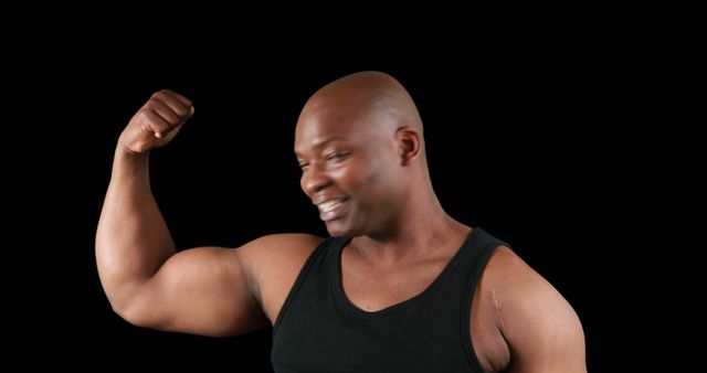 African american strong man flexing muscles with copy space on black background. Boxing, strength, fitness concept.
