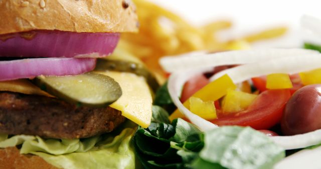 Close-up photo of a gourmet burger with a side of fresh salad. The burger displays layers of lettuce, pickles, cheese, and red onion slices in a soft bun. The salad features tomatoes, bell peppers, onions, and olives. Ideal for promoting health-conscious fast food choices, restaurant menus, or food blogs focusing on balanced meals.
