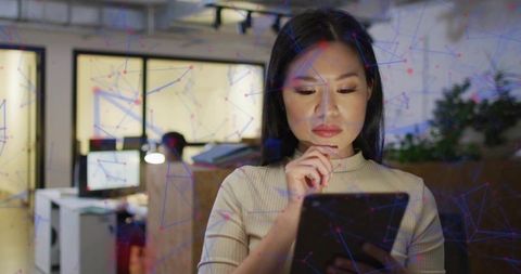Woman Holding Tablet with Digital Network Overlay in Modern Office