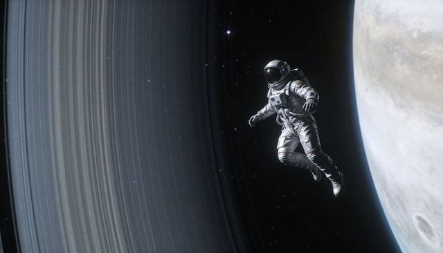 Solitary astronaut floating near massive ringed planet, drifting through deep space void
