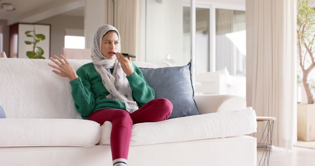 Woman Relaxing on Couch with TV Remote in Modern Living Room - Download Free Stock Images Pikwizard.com