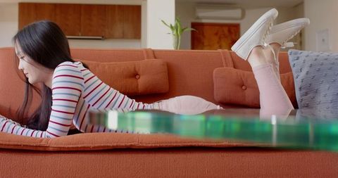 Woman relaxing on sofa in modern living room