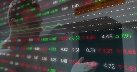 Market analyst reading real-time financial data on transparent touchscreen with color arrows