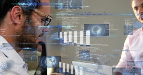 Analyzing business data with futuristic HUD overlays, team collaborating over laptop