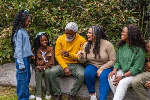 Multigenerational african american family exploring nature together on park bench