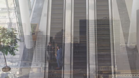 Businessmen Communicating on Escalator With Cityscape Reflection