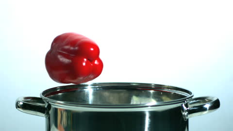 Red Pepper Falling into Saucepan in Slow Motion