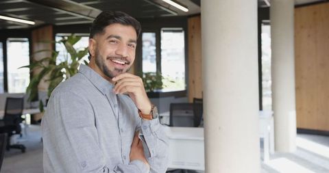 Confident professional smiling in modern office setting with copy space