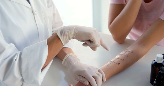 Doctor conducting an allergy test on patient's arm in an examination room. Useful for topics related to healthcare, diagnostic procedures, allergy testing, patient care, and medical examinations.