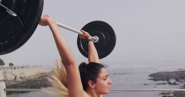 Determined Woman Weightlifting Outdoors Near Ocean - Download Free Stock Images Pikwizard.com