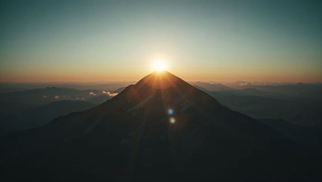 Sun Rising Above Majestic Volcanic Mountain Peak