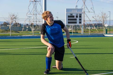 Field Hockey Player Pausing on Turf on Sunny Day