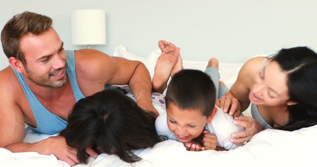 Happy Family Playing and Laughing on Bed - Download Free Stock Images Pikwizard.com