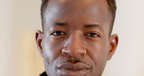 Confident man with hoop nose ring inside home