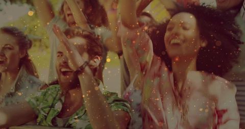Friends cheering at backyard party celebrating summer with confetti and sunlit laughter