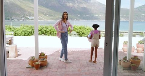 Mother and daughter relaxing on scenic terrace overlooking bay