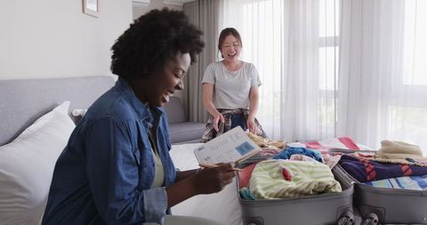 Mixed Heritage Lesbian Couple Packing for Vacation at Home