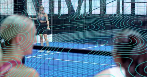 Female athlete walking on blue indoor court with spectators and teal contour overlay