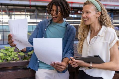 Diverse coworkers analyzing charts in office atrium